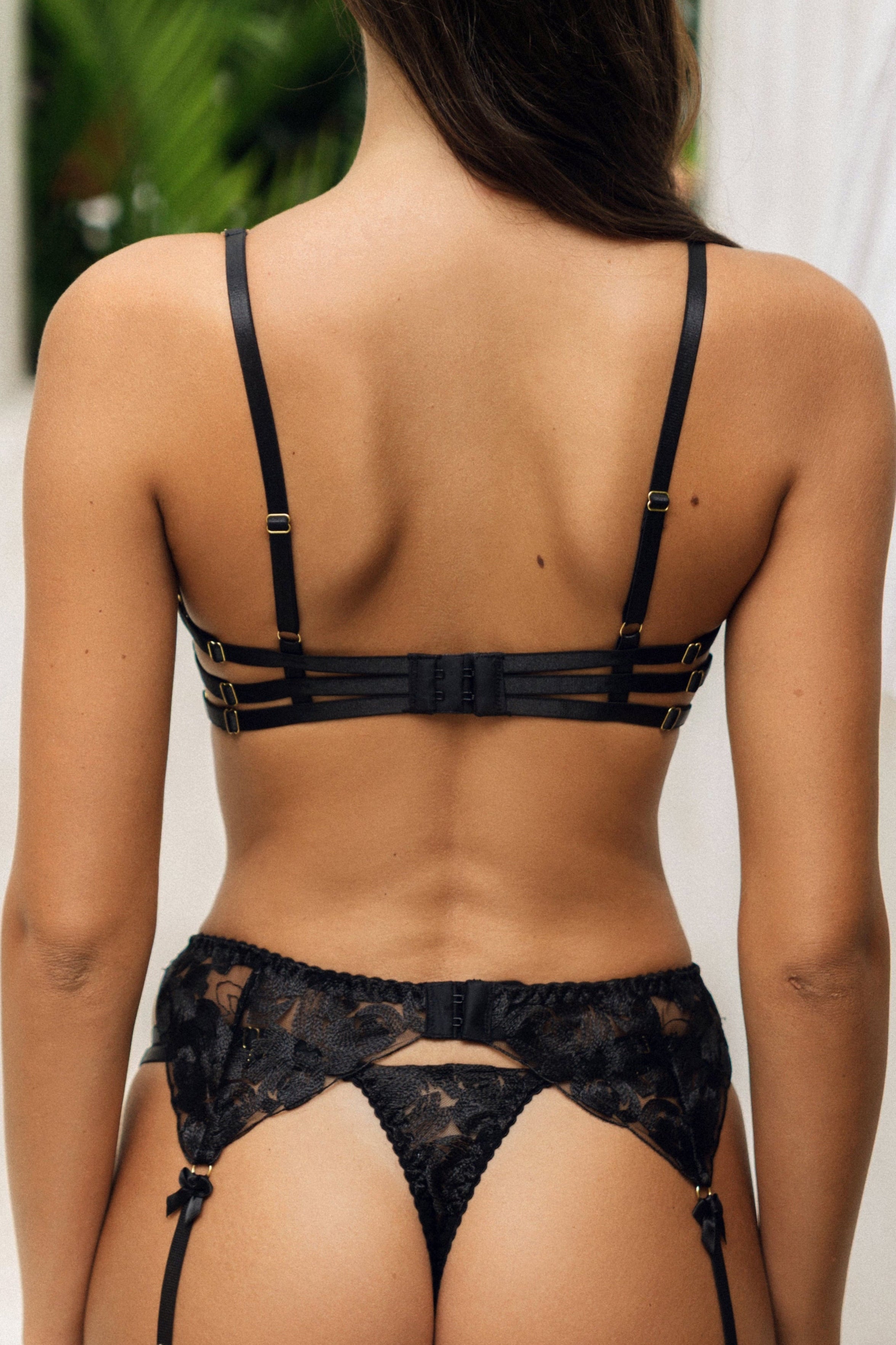 Seira Lace Alexis black underwired bra for women, crafted from sheer black lace with intricate floral embroidery. The bra features a delicate silhouette, enhanced with gold-accented jewel strap detailing for a luxurious and sensual touch. A bold and elegant piece designed to offer both support and allure.