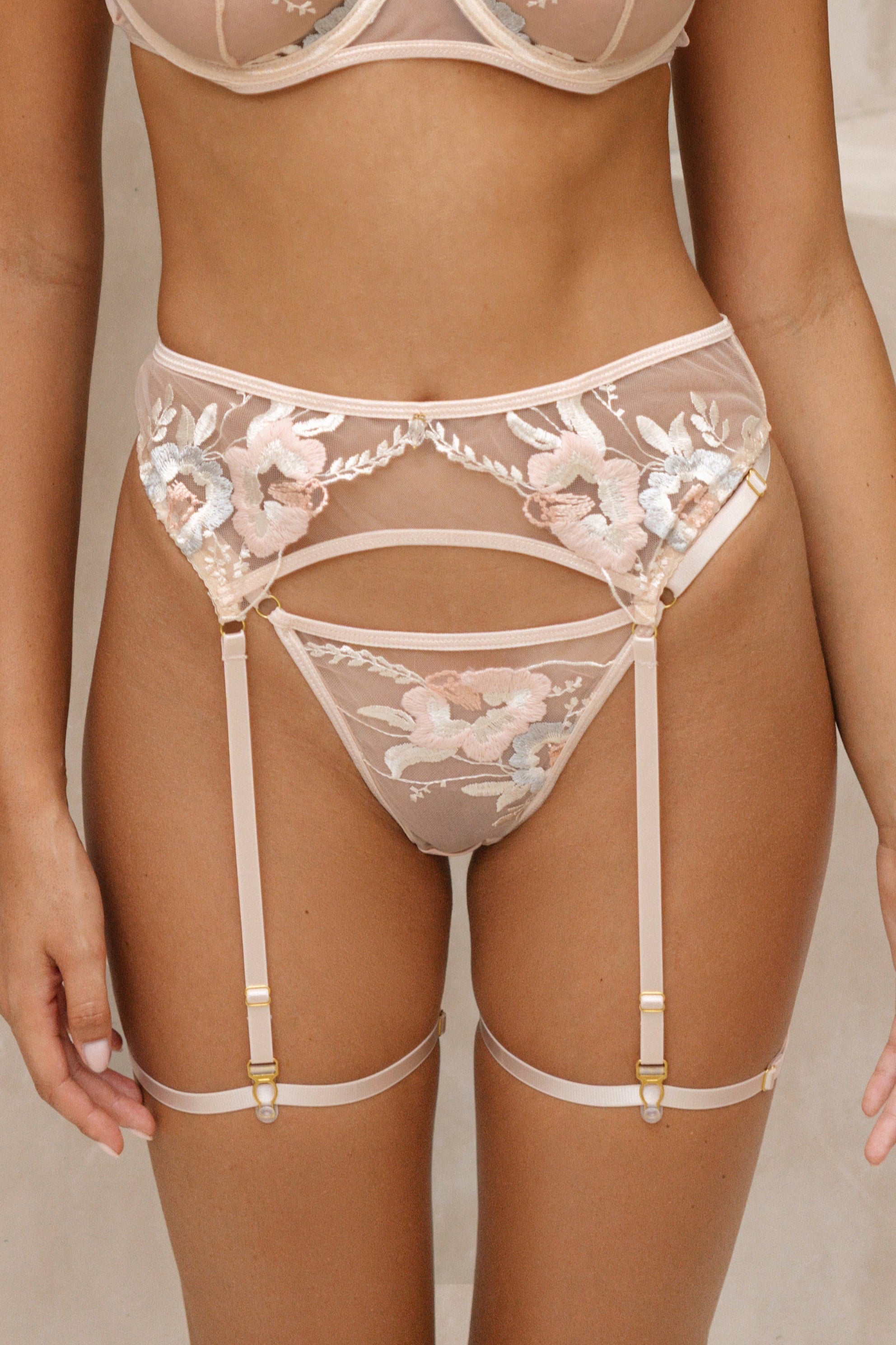 Seira Lace Rosie pink detachable garter belt for women, crafted from sheer mesh with intricate floral embroidery. The adjustable garter belt wraps around the waist, enhancing the silhouette with a touch of romance and allure. A luxurious and seductive piece, designed to complement the Rosie bra and thong for a complete lingerie set.