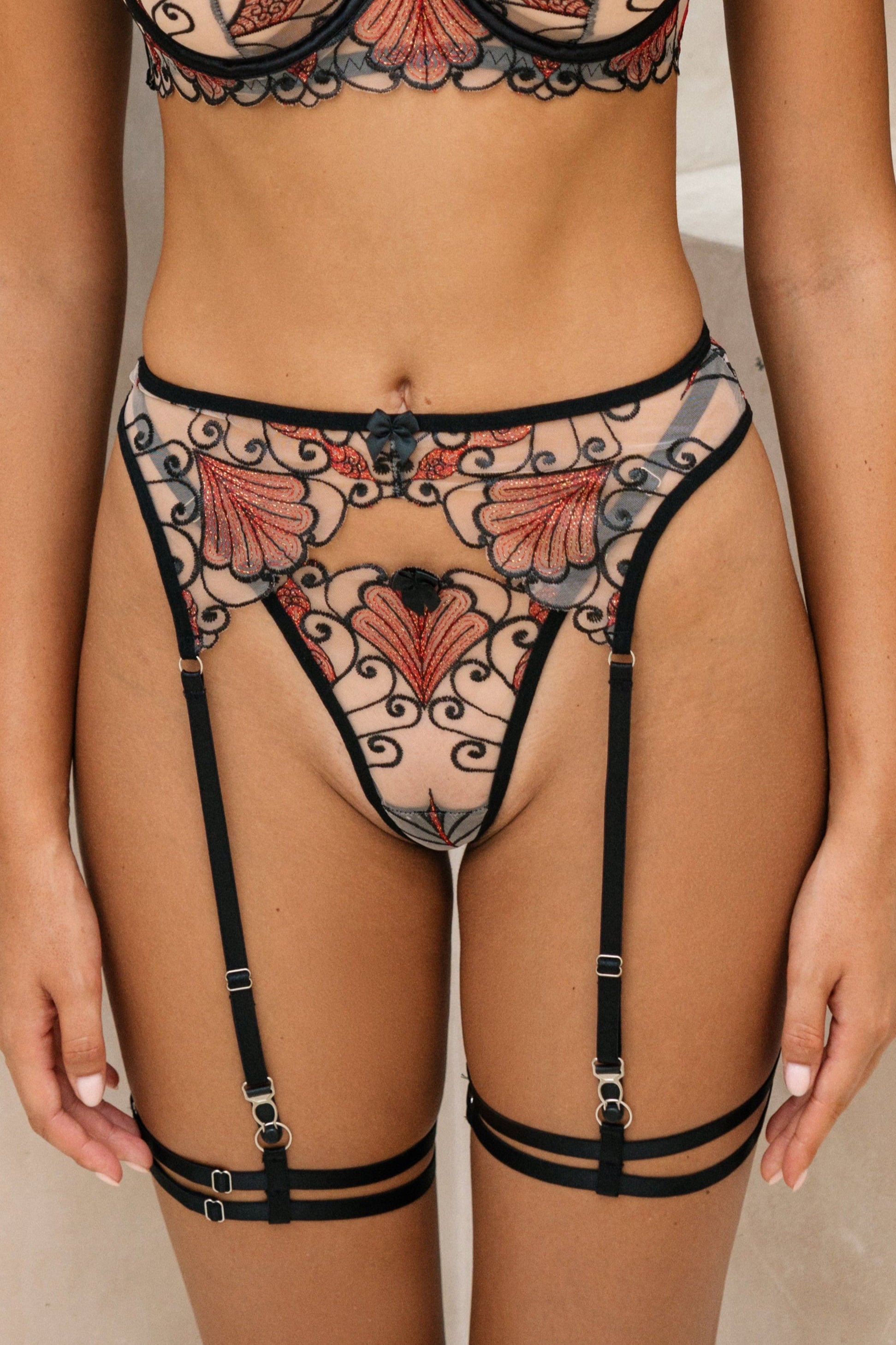 Seira Lace Natalia black and red garter belt for women, featuring delicate floral lace and adjustable straps for a customizable fit. The elegant design includes a smooth waistband and vintage-inspired styling, perfect for pairing with matching lingerie sets for a seductive and luxurious look.